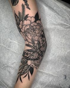 a woman's leg with black and white flowers on it