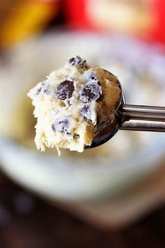 a spoon full of ice cream with chocolate chips on it and a bite taken out