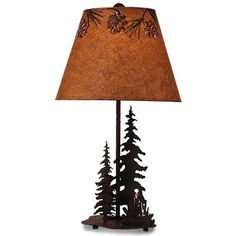 a lamp that is sitting on top of a wooden base with pine cones and leaves