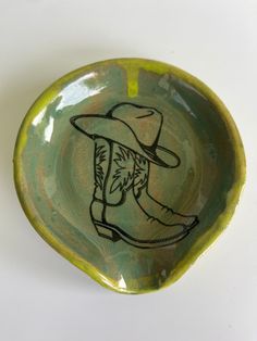 a green bowl with a drawing of a man in a cowboy hat on the side