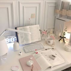 an open book sitting on top of a white desk next to a keyboard and mouse