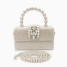 Shaped in a timeless box form, the Anisha Rhinestones Handbag exudes an irresistible allure. However, what truly distinguishes it is its one-of-a-kind handle—a statement piece designed to captivate attention and elevate your ensemble to new heights. With its generous interior, this bag offers ample space for all your essentials, seamlessly blending practicality with undeniable style. Now available in gold and silver. Luxury Silver Rectangular Box Bag, Elegant Crystal Bags With Rhinestones, Elegant Silver Box Bag With Top Handle, Chic Rhinestone Shoulder Bag As Gift, Formal Rhinestone Top Handle Bag, Luxury Rectangular Box Bag With Pearl Handle, Rectangular Crystal Party Bag, Luxury Silver Shoulder Bag With Pearl Handle, Glamorous Silver Bag With Detachable Handle