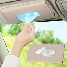 a hand holding a tissue in the back seat of a car