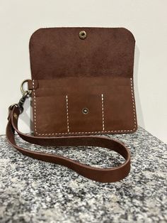 a brown purse sitting on top of a stone counter