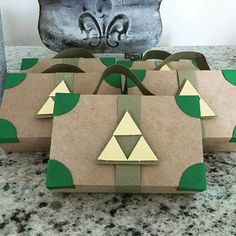 three brown paper bags sitting on top of a counter covered in green and white shapes