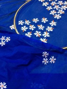 a blue cloth with white daisies on it and gold trimming around the edges