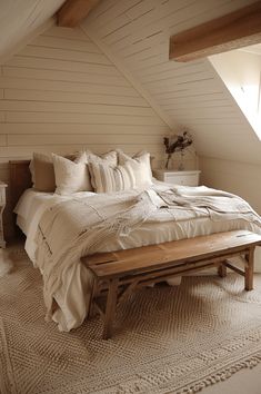 a bed sitting in the middle of a bedroom under a slanted ceiling with two windows