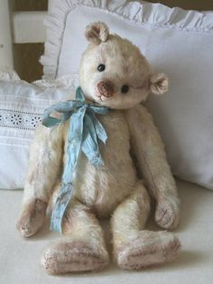 a white teddy bear sitting on top of a bed