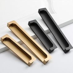 three different types of door handles on a white surface, one black and one gold