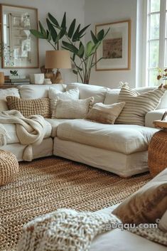 a living room filled with lots of white furniture and large pillows on the couches