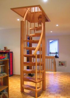 a wooden spiral staircase in the middle of a living room next to a man looking at it