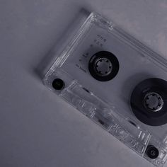 an audio cassette with two black wheels on it