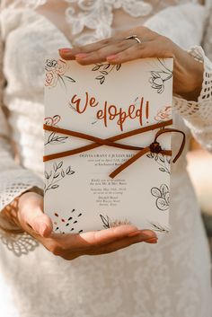 a person holding a wedding card in their hands with the words we beloved written on it