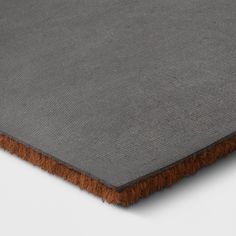 an area rug with brown fringes on the bottom and grey carpet in the middle