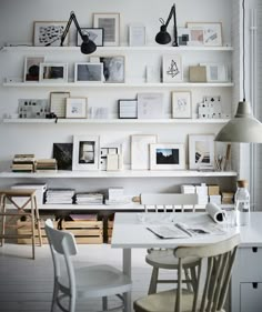 a white table and chairs in a room with books on the shelves above it,