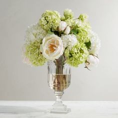 a vase filled with white and green flowers