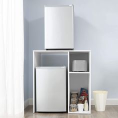 a white refrigerator freezer sitting on top of a wooden floor