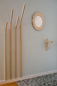 three wooden sticks are standing next to a clock