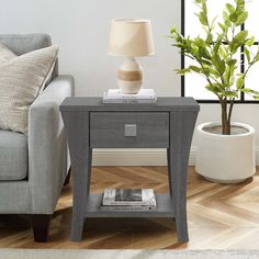 a grey end table with a lamp on top and a magazine in front of it