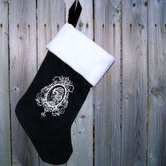 a black and white stocking hanging on a wooden fence with an image of a woman