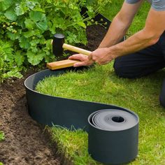 a man is working in the garden with gardening tools and grass on the ground next to him