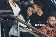 a man and woman kissing in the stands