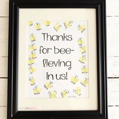 a black frame holds a yellow and white print with the words thanks for bee - blowing in us