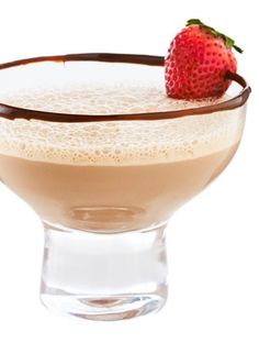 a glass filled with liquid and a strawberry on the top, sitting in front of a white background