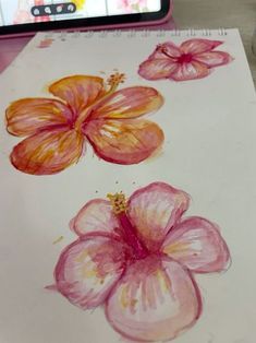 a drawing of three flowers on paper with a cell phone in the backgroud