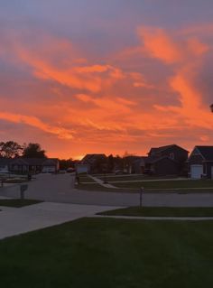 the sun is setting behind some houses