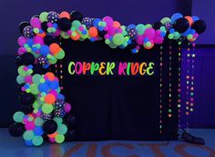 an arch made out of balloons and streamers with the words copper ridge on it