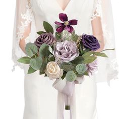 a bride holding a bouquet of purple and white flowers on her wedding day in front of the camera