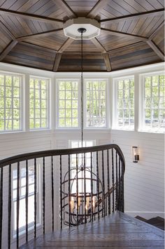 the inside of a house with white walls and wooden floors, windows, and railings