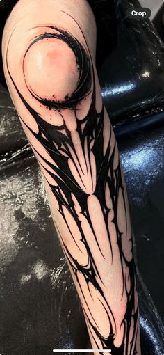 a man's leg with black ink on it and an abstract design in the middle