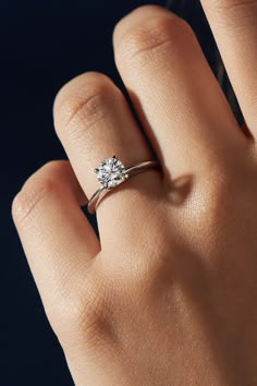 a woman's hand with a diamond ring on it