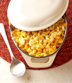 a bowl filled with macaroni and cheese on top of a red place mat