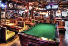 a pool table in a room with many tables and chairs