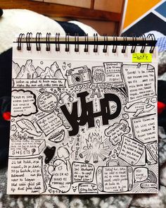 a notebook covered in doodles with the word ylp written on it next to a teddy bear