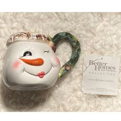 a ceramic mug with a snowman face on it