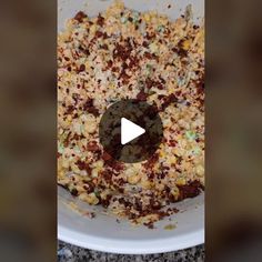 a bowl filled with corn and seasoning on top of a counter