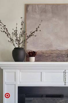 a white fireplace mantel topped with a potted plant and a painting on the wall