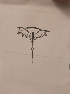 a piece of paper with a drawing of a bat hanging from it's side