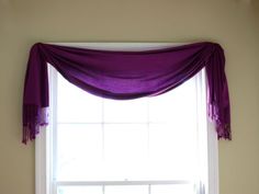 a window with a purple curtain hanging over it