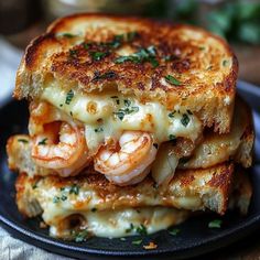 two grilled cheese sandwiches stacked on top of each other with shrimp in the middle