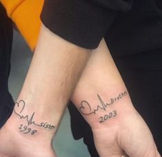 two people holding hands with tattoos on their wrists and the words love is written in cursive writing