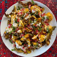 a white plate topped with lots of food on top of a red and blue table cloth