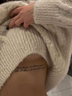 a woman with a tattoo on her lower back is holding onto the side of her stomach