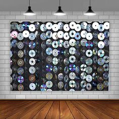 an empty room with wooden floors and a large wall hanging on the wall, filled with cd's