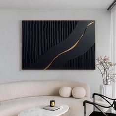 a black and gold abstract painting hangs on the wall above a white couch in a modern living room