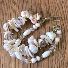 Crystal Sea Shell From North Carolina And Virginia Shores. Solid Brass Handmade Clasp. Real Glass Crystals. Many Years Of Collecting. 8” But Fits A Wide Range Of Wrists. Has Extender Ring. I Have Made Another Smaller One, So Check That One Out Along With My Other Artisan Handmade Bracelets. Tags: Coastal, Boho, Maximalist, Beach, Beachy, Handmade, Treasure Chest, Gift Jewelry, Brass Vintage Multi-strand Beach Jewelry, Vintage Multi-strand Jewelry For Beach, Vintage Multi-strand Jewelry For The Beach, Maximalist Jewelry, Boho Style Bracelets, Dragon Bracelet, Coastal Boho, Large Bracelet, Purple Quartz